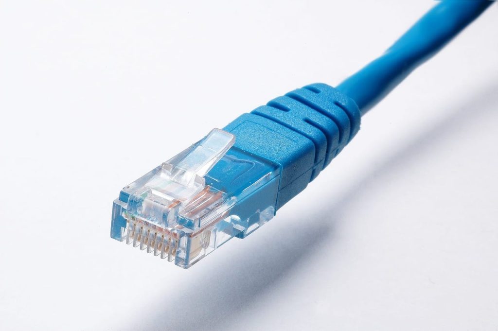 pexels photo 415043 High-quality image of a blue Ethernet cable plug on a white background, ideal for tech themes.
